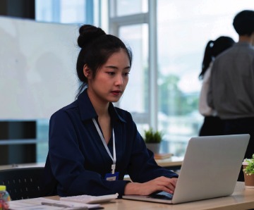 Estudante concentrada usando notebook em um escritório